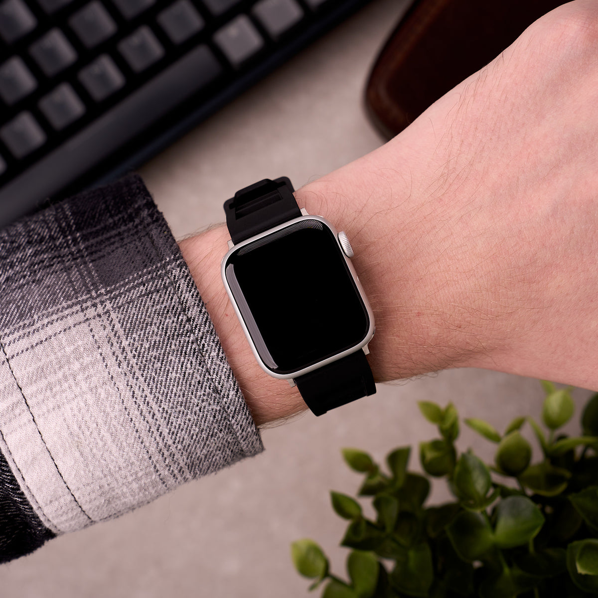 The Bastion FKM rubber Apple Watch band in Black worn on the wrist with an Apple Watch