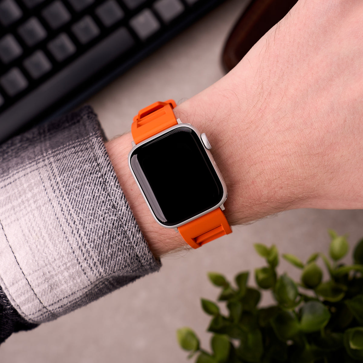 The Bastion FKM rubber Apple Watch band in Orange worn on the wrist with an Apple Watch
