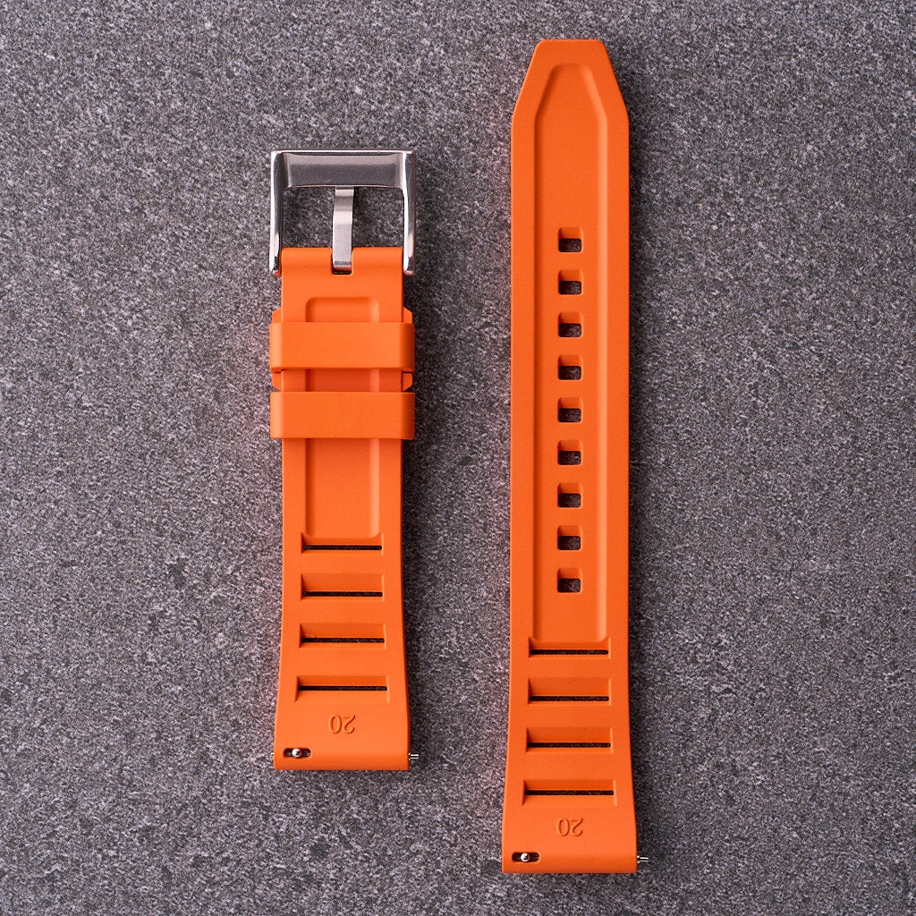 Underside of The Bastion orange FKM rubber strap showing vented design and stainless buckle, fitting 20mm 22mm and 24mm watch lugs.