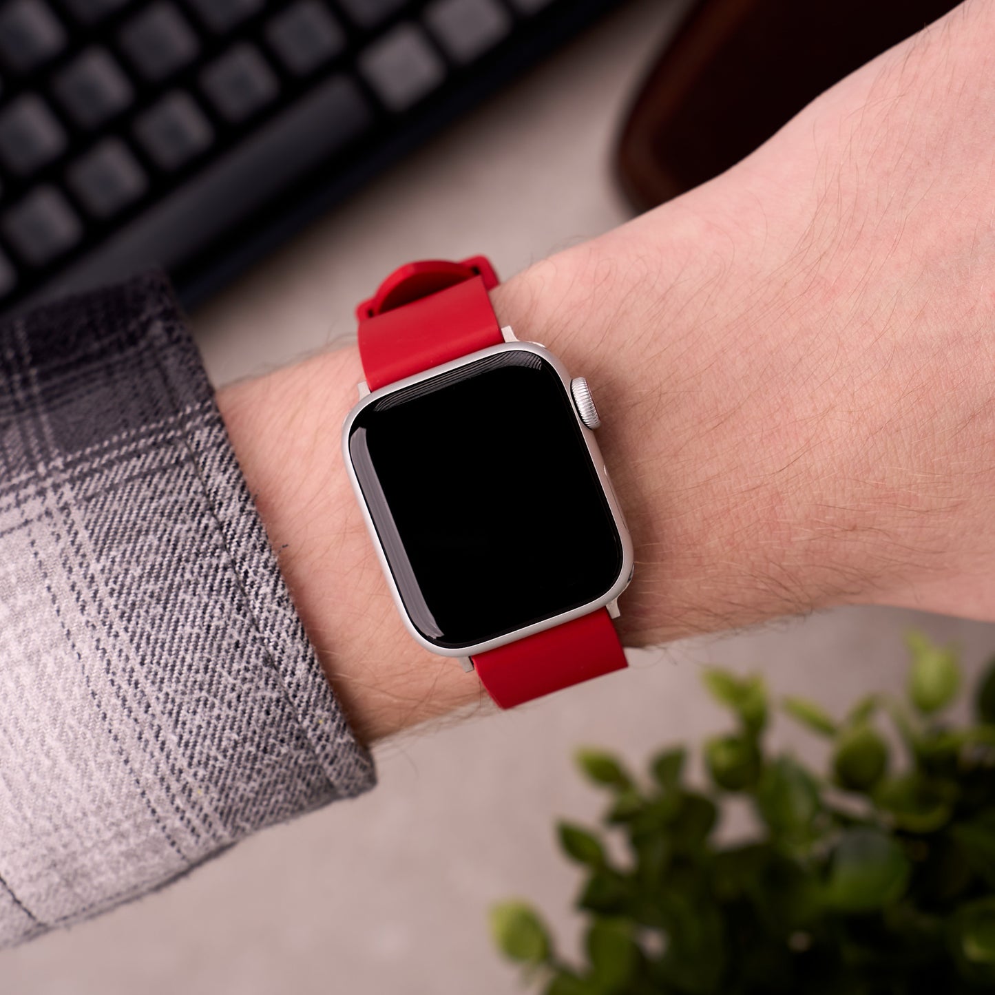 The Callaway FKM rubber Apple Watch band in Red worn on the wrist with an Apple Watch