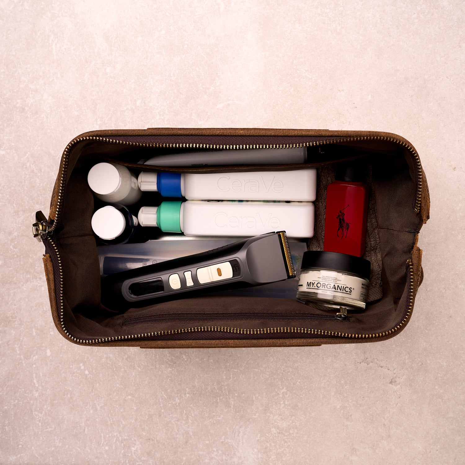 The Grafton leather toiletry bag packed with clippers, skincare bottles and hair products