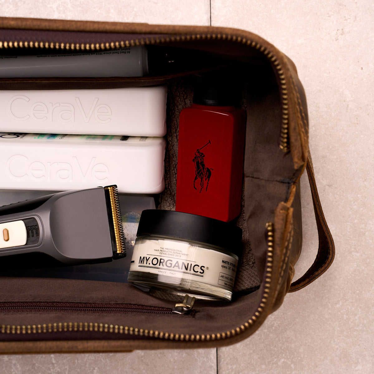 Close up of The Grafton toiletry bag packed with clippers, a straightener and grooming products
