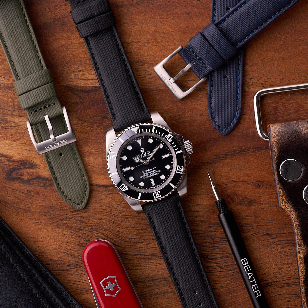 Army green Harbour waterproof strap pictured with navy blue and black straps in a flat lay scene.