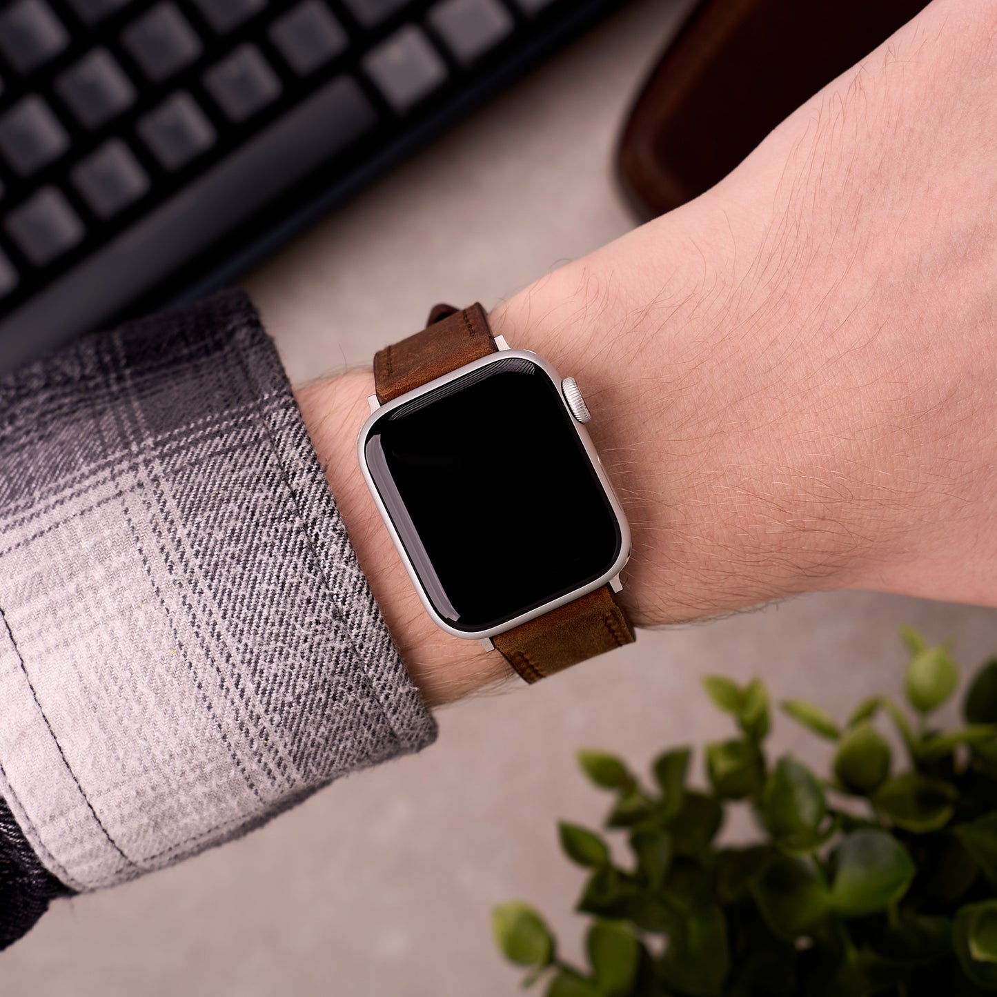 The Harrington leather Apple Watch band in Brown worn on the wrist with an Apple Watch
