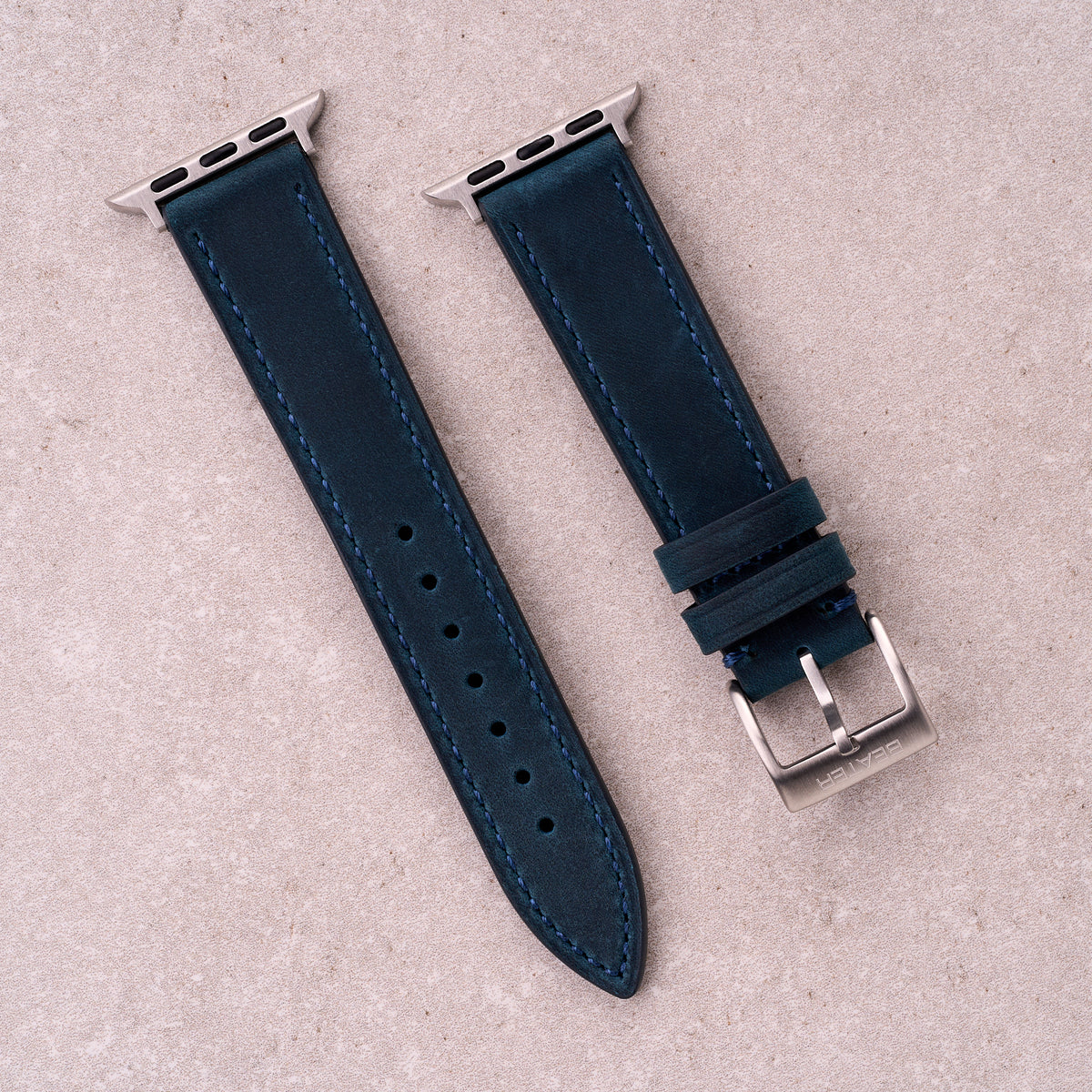 The Harrington leather Apple Watch band in Navy Blue, front view showing the full strap and buckle