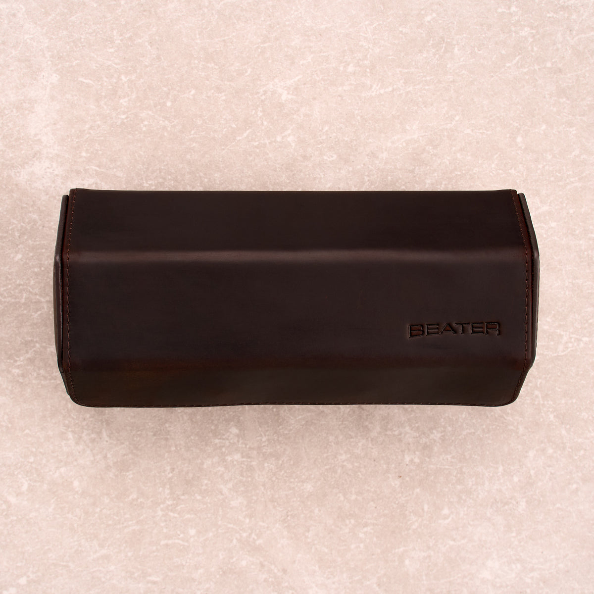 The Ashford leather watch roll closed, shot top down, with the Beater logo embossed on the lid