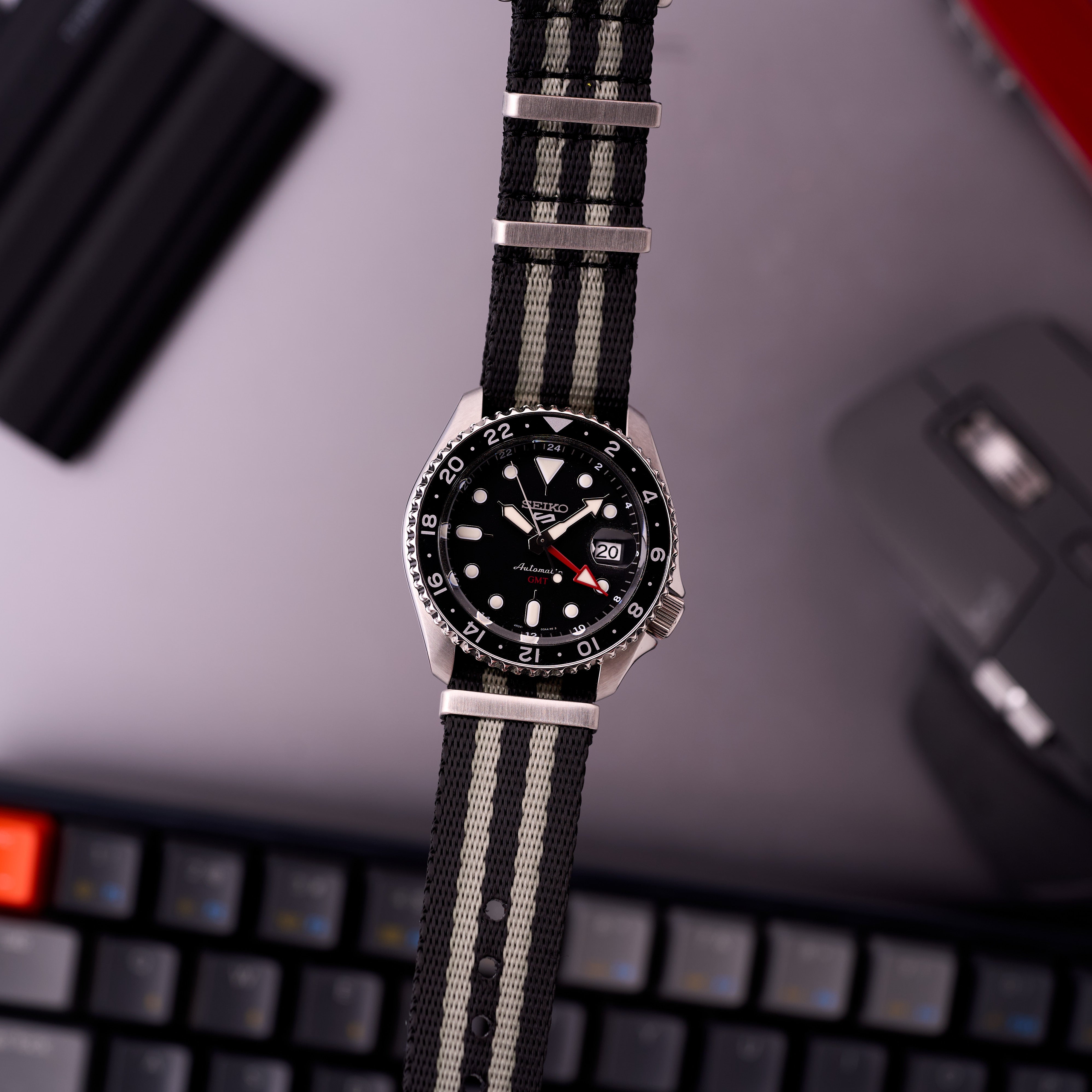 Close detail of The Operator James Bond NATO strap showing striped corrugated weave, metal keepers and buckle hardware.