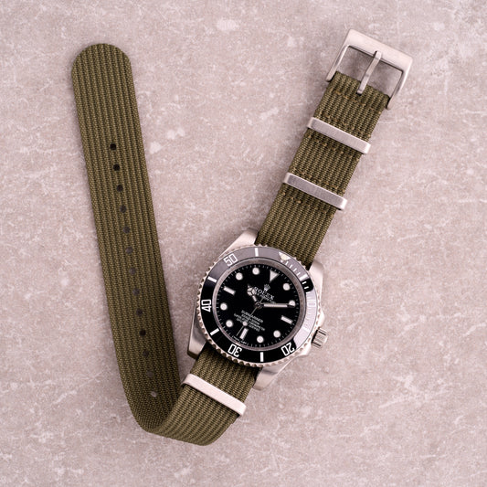 The Operator olive green corrugated NATO strap, military-inspired nylon one-piece watch band with brushed steel hardware.