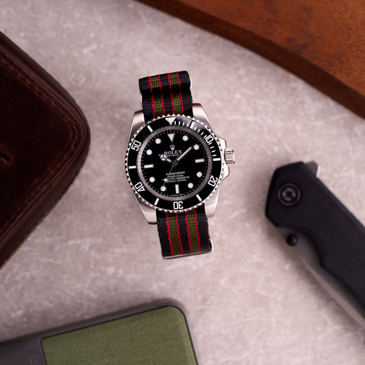 Watch on The Sentinel 007 black green and red striped NATO strap in a lifestyle scene, making a colourful Bond-style statement on wrist.