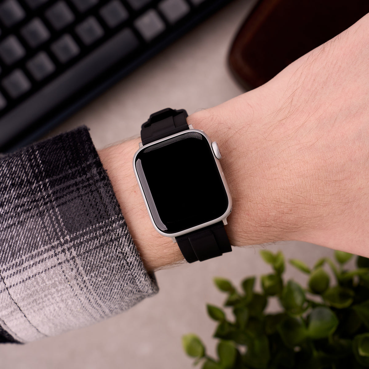 The Specter FKM rubber Apple Watch band in Black worn on the wrist with an Apple Watch