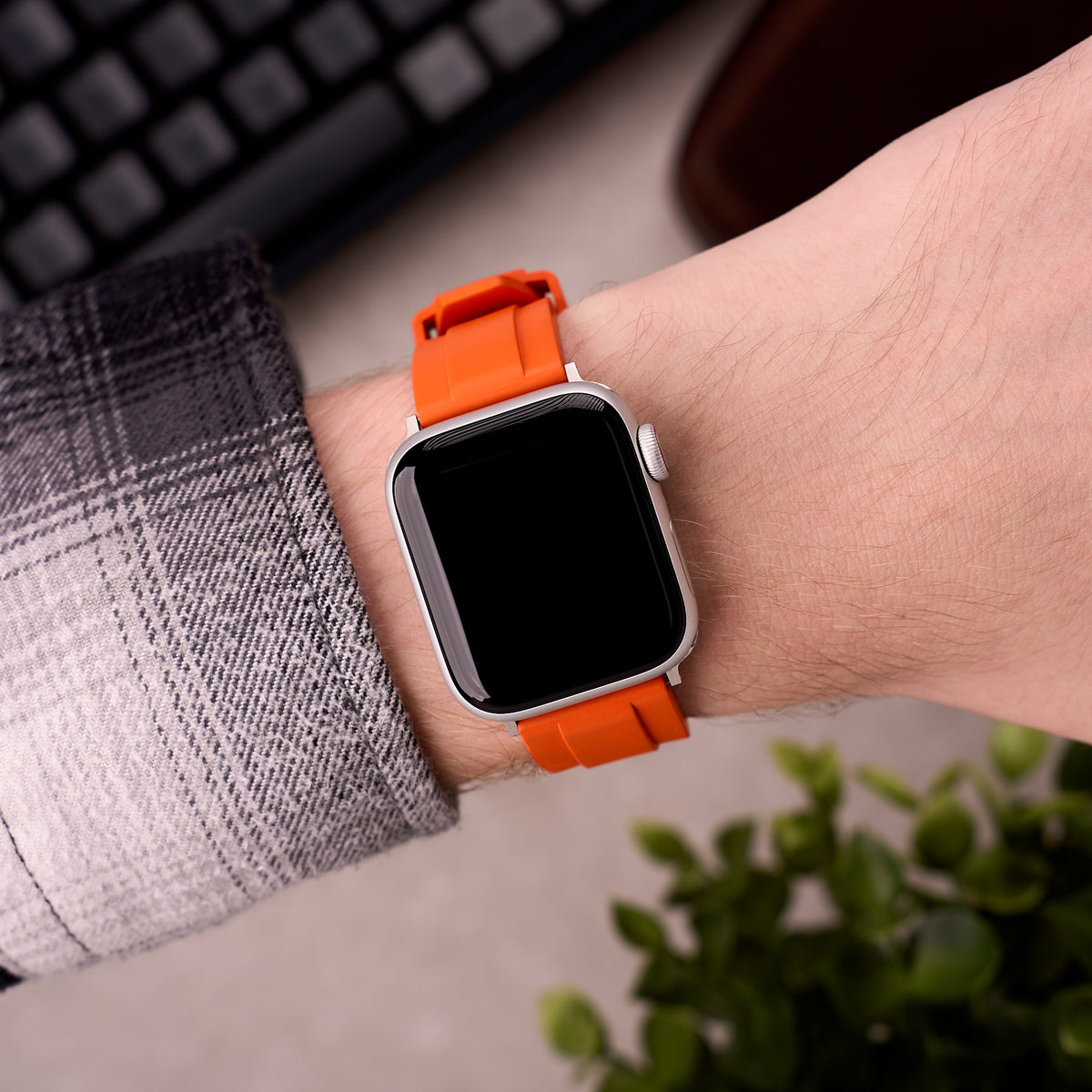 The Specter FKM rubber Apple Watch band in Orange worn on the wrist with an Apple Watch
