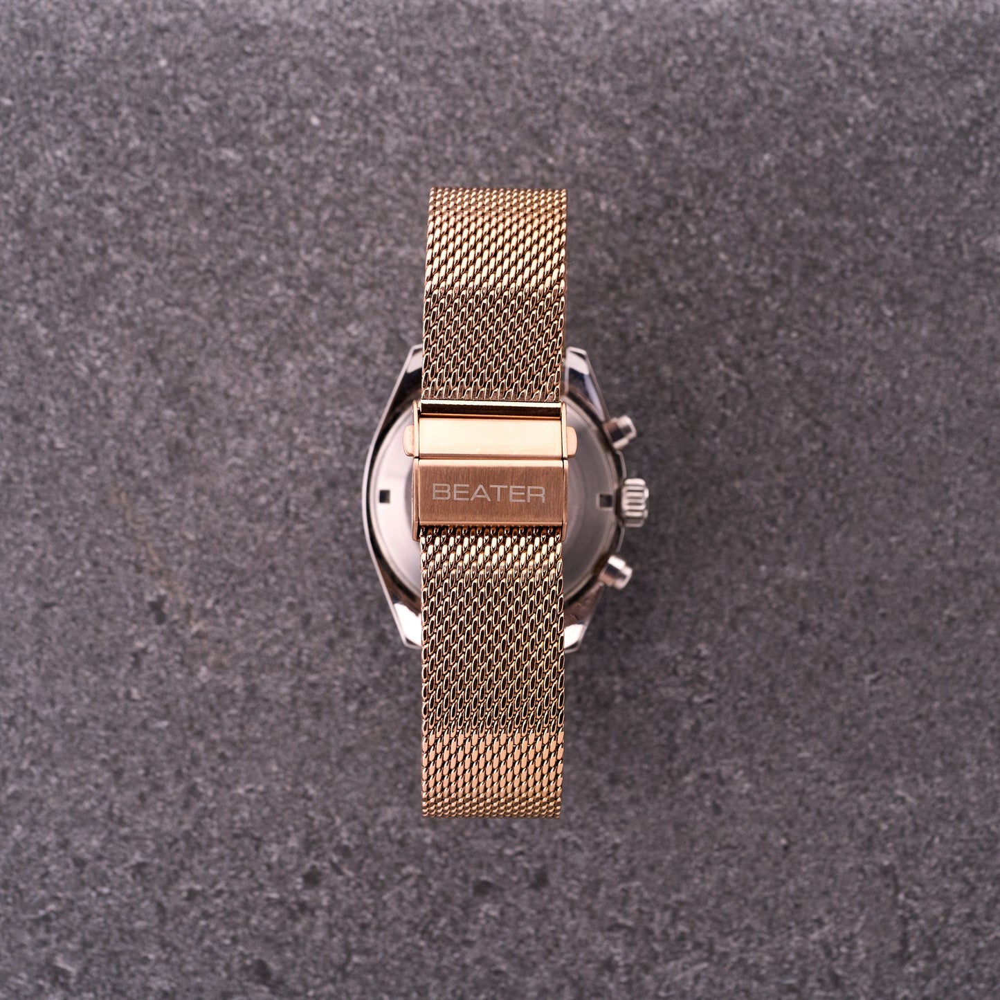 Close-up of The Sterling bronze rose mesh bracelet clasp and logo, highlighting polished hardware and tightly woven mesh links.