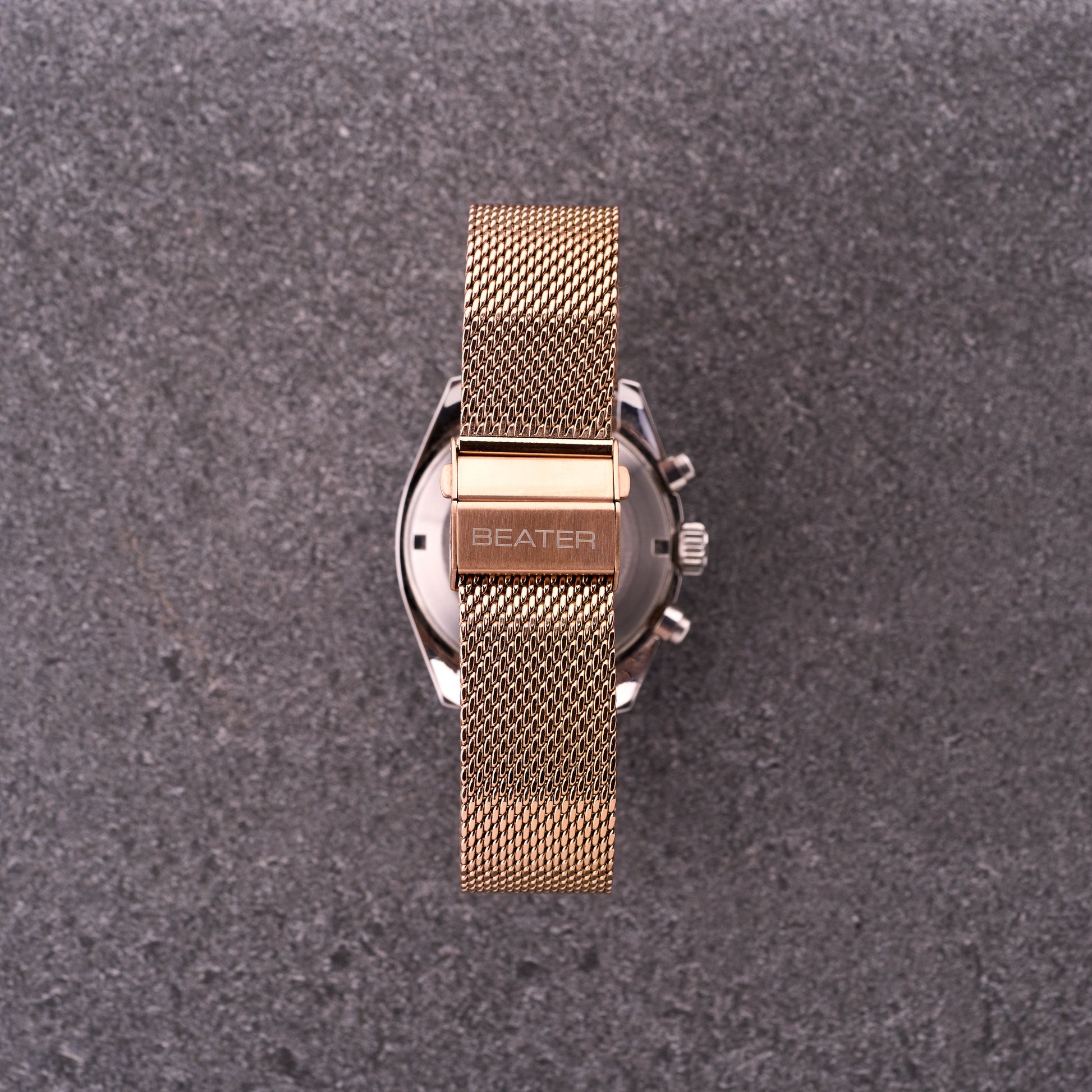 Close-up of The Sterling bronze rose mesh bracelet clasp and logo, highlighting polished hardware and tightly woven mesh links.