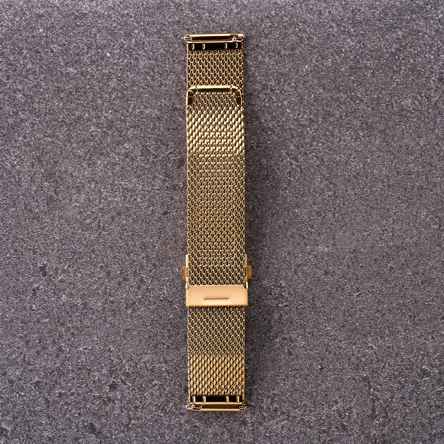 The Sterling gold mesh stainless steel watch strap laid flat, showing quick-release connectors and sliding clasp for easy sizing.