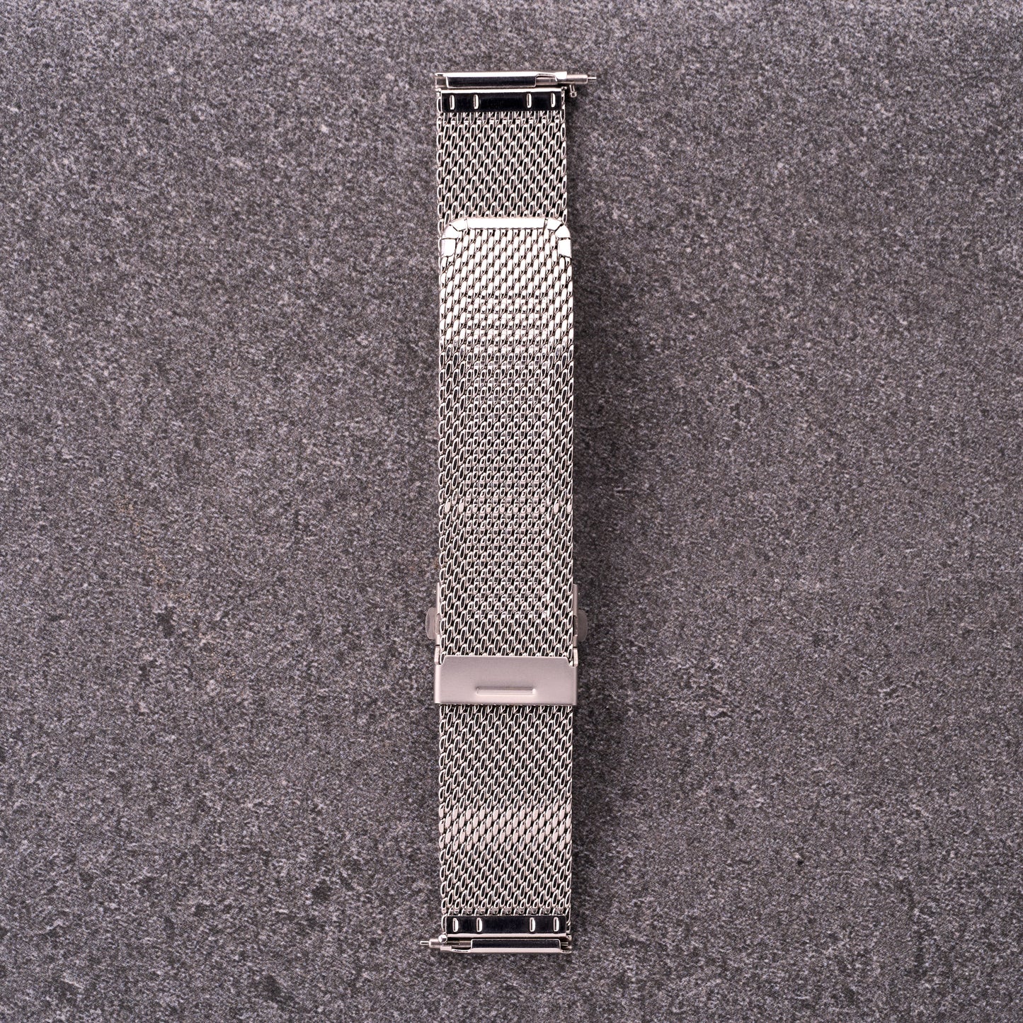 The Sterling silver mesh stainless steel watch strap laid flat, showing quick-release ends and adjustable sliding clasp.