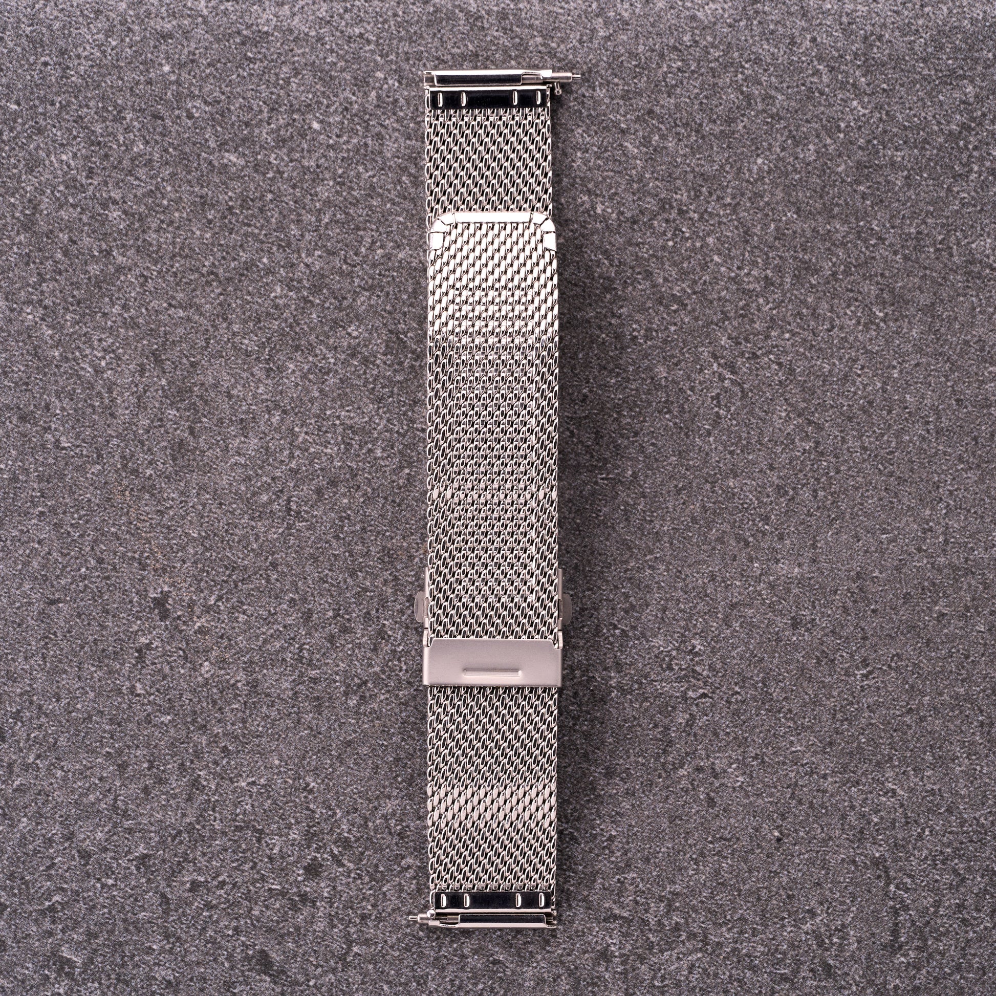 The Sterling silver mesh stainless steel watch strap laid flat, showing quick-release ends and adjustable sliding clasp.